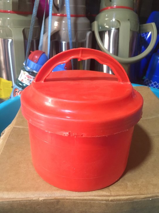 Red plastic bucket with a lid and a handle